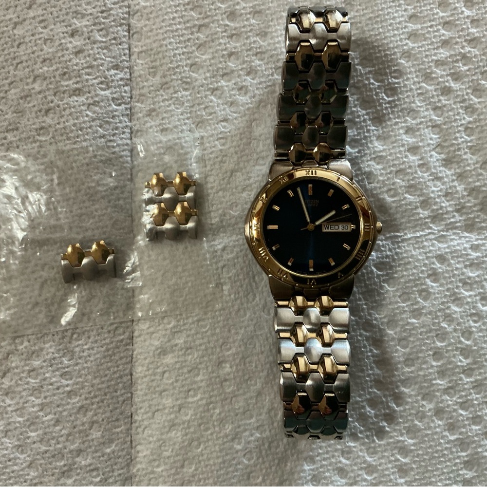 Men’s Citizens quartz watch with two tone gold and silver band.